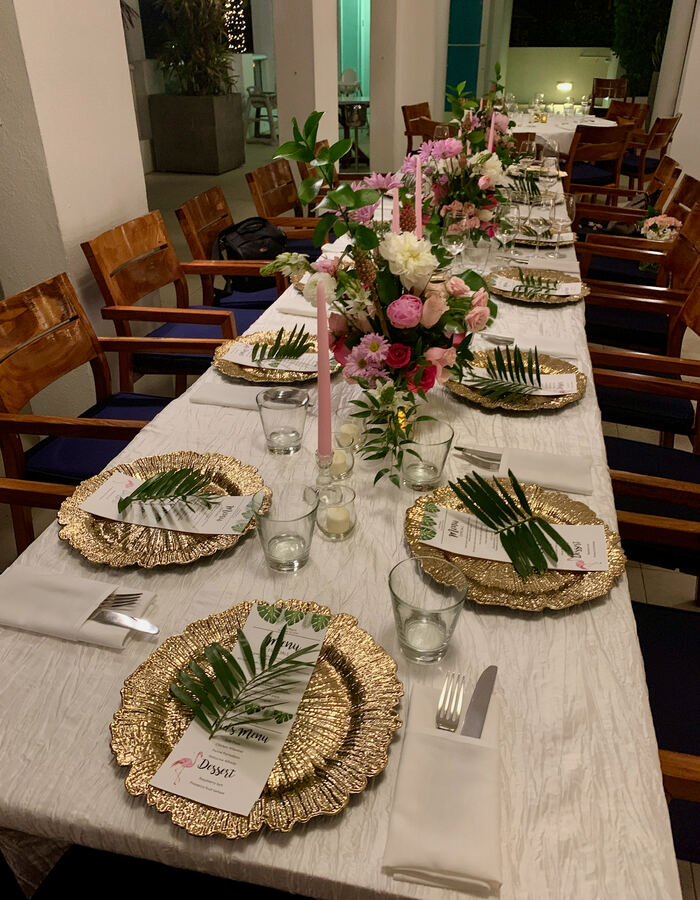 Miami: gold chargers, palm leaves, pink tapers, long table