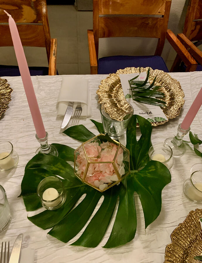 Miami: monstera leaf, gold chargers, pink tapers, close
